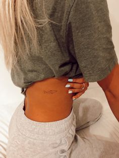 a woman's lower back tattoo with the word love on her left ribcage