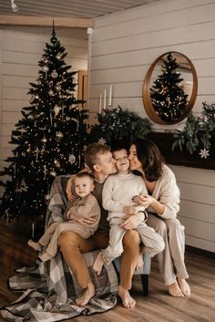 a family sitting on a couch in front of a christmas tree