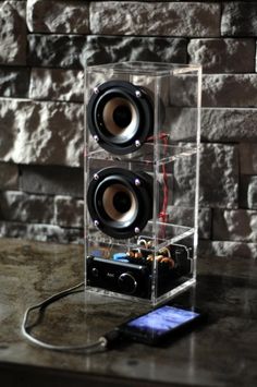 two speakers sitting on top of a table next to a cell phone