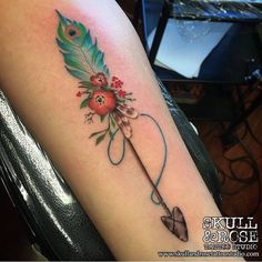 a woman's arm with an arrow and flowers on it