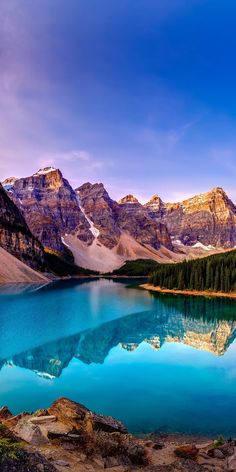 a lake surrounded by mountains with blue water