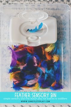 the feather sensory bin is packed with colorful feathers and has a plastic lid for storage