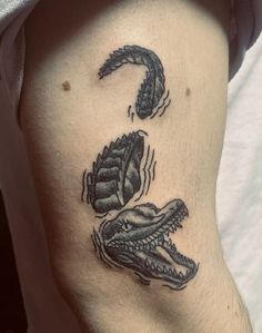 a close up of a person's leg with tattoos on it and an alligator