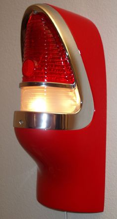 a close up of a red light on a wall with a white wall in the background