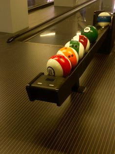 a row of bowling balls sitting on top of a conveyor belt in a building