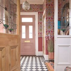 an entry way with a checkered floor and wallpaper on the walls is shown