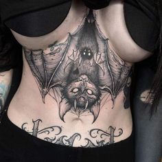 a woman with a bat tattoo on her stomach