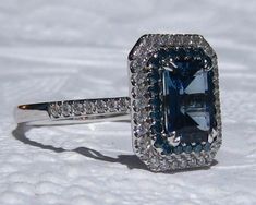 an engagement ring with a blue diamond surrounded by white diamonds