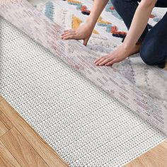 a person kneeling down on a rug with their feet in the floor and one hand reaching for something