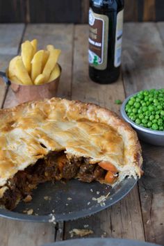 there is a pie with meat and vegetables on the table