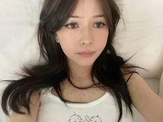 a woman with long hair laying in bed