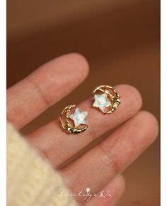 a person is holding their hand up with two small rings on it's fingers