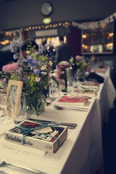 the table is set with books and flowers