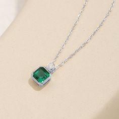 This exquisite pendant necklace showcases a brilliant emerald in a classic solitaire setting, radiating a lush green hue. Its elegant simplicity makes it a standout piece, perfect for enhancing any neckline with a touch of refined sophistication. Emerald Necklace In Brilliant Cut, Fine Jewelry Green Emerald Necklace With Brilliant Cut, Fine Jewelry Emerald Necklace With Brilliant Cut, Green Brilliant Cut Necklace For May Birthstone, Elegant Emerald Pendant Necklace With Bezel Setting, Green Emerald-cut Diamond Necklace, Minimalist Green Emerald Necklaces, Green Fine Jewelry Necklace For Formal Occasions, Elegant Green Emerald Necklace With Brilliant Cut