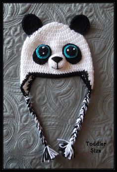 a crocheted panda bear hat with blue eyes