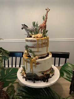 a three tiered cake with zebras and giraffes on top