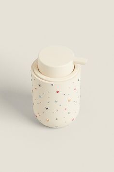 a white cup with a lid and sprinkles on it