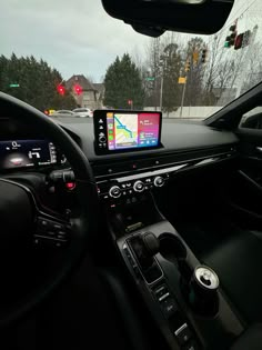 the dashboard of a car with an electronic device in it's center console, along with other vehicles