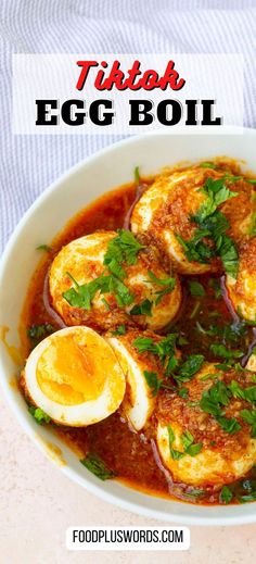 a bowl filled with eggs and sauce on top of a table