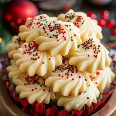 some cupcakes with white frosting and sprinkles in a bowl