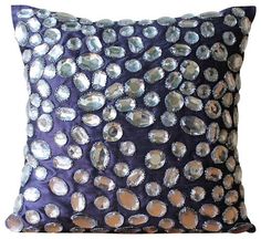 a purple and silver pillow with circles on it's side, against a white background