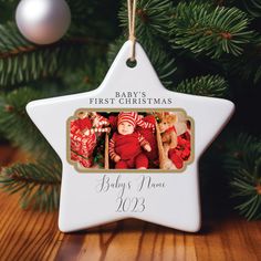 a baby's first christmas ornament hanging from a tree