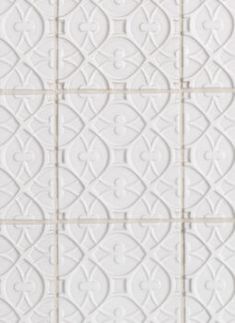 a white tile wall with an intricate design