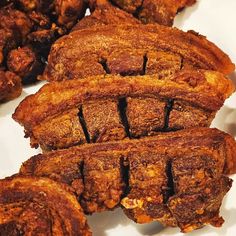 several pieces of meat sitting on top of a white plate