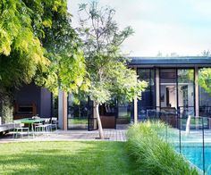 an outdoor swimming pool surrounded by trees and grass