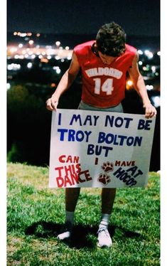 a man holding a sign that says i may not be troy bottom but i can have dance