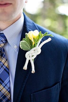 a man wearing a suit and tie with a boutonniere on his lapel