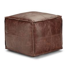 a brown leather square ottoman sitting on top of a white floor