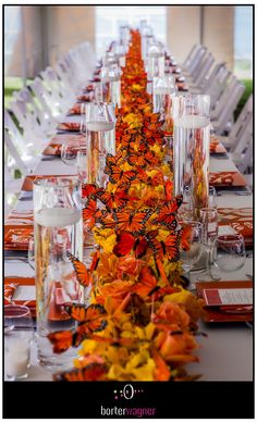 the long table is decorated with orange and yellow flowers