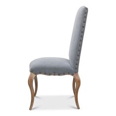 an upholstered chair with wooden legs and studded trimmings on the back