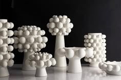 several white vases and sculptures on a table