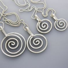 "A silver spiral necklace that's simple and whimsical. Dress it up or down- created to inspire the celebration of life and freedom in the wearer.  Each swirl charm is sterling silver- no two are alike.  Choose whether you'd like your spiral necklace with light texture and shiny or textured and oxidized. Keeping wild places close to your heart The spiral is a powerful symbol and has many meanings- balance, direction, initiation, centering- just to name a few.  As an artist, creating spiral jewelry mimics the occurrence of the spiral in nature. Additionally, I have been inspired by spirals on canyon walls in the Southwest- and believe this to symbolize migration. These drawings often lead to water. Make a perfect set https://www.etsy.com/listing/484609241/spiral-jewelry-silver-jewelry-silver Spiral Jewelry, Mountain Earrings, Metal Pendant Necklace, Whimsical Dress, Mountain Jewelry, Spiral Necklace, Mixed Metal Jewelry, Spiral Earrings, Silver Snake Chain