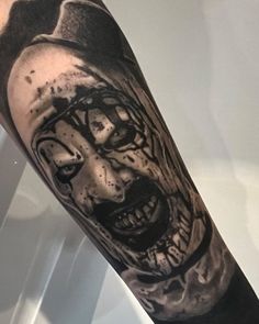 a man's arm with a scary clown tattoo on it