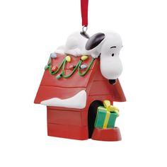 a snoopy christmas ornament hanging from a red roof