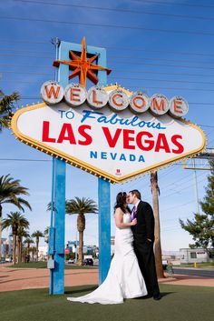 a bride and groom pose in front of the welcome to fabulous las vegas sign on their wedding day