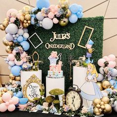 a table topped with lots of cake next to balloons and other decorations on top of it