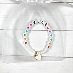 This colorful heart bracelet makes a great birthday gift! The white beads and heart charm make the heart beads pop! Personalize this bracelet for someone you love ❤️ The bracelets are beautifully packaged and ready to gift. Receipts are never included in your package. If you want to include a special note, please let me know in the comments. Roll, don't pull. To avoid excess stretching please roll the bracelet on and off. Treat and store the bracelets gently. Sizing options are just a guideline. Kids Name Bracelet, Bracelet For Kids, Girls Bracelet, Bracelets Charm, Crafts Cricut, Fun Bracelet, Bracelet Heart, Baby Bracelet, Presents For Kids