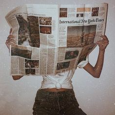 a woman holding up a newspaper with her face covered by the paper and hands behind her head