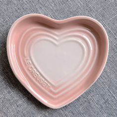 a heart shaped dish with the word love written on it