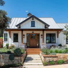 a white house with a wooden door and steps leading up to the front porch area