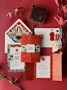 the wedding stationery is laid out on top of each other, with flowers in vases next to it