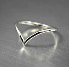 Dainty .925 sterling silver V curve wishbone ring. Minimalist chevron design for everyday wear. Handmade in 14 gauge wire.  Available in shiny finish. SIZES: 3-16 MORE SILVER RINGS: https://www.etsy.com/ca/shop/JenniferWoodJewelry?ref=seller-platform-mcnav&section_id=37080248  Established Etsy Seller since 2006. Get 15% off when you join my email list to receive monthly updates about new work and subscriber-only deals. No spam. Just a lot of shiny new things. Subscribe at: http://eepurl.com/iqWq Morganite Engagement Ring Set, Pink Morganite Engagement Ring, Wishbone Ring, Arrow Ring, Silver Ring Designs, Chevron Ring, Morganite Engagement Ring, Midi Rings, Wire Rings