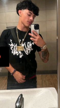 a man taking a selfie in a bathroom mirror with his cell phone up to his ear