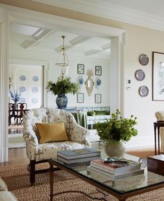 a living room filled with lots of furniture and flowers on top of a coffee table