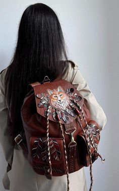 Fox womens leather backpack is my author's manual work! Materials: genuine brown leather, metal hardware, acrylic paints Sizes: 12 inches (width), 14 inches (height), 8 inches (depth). There is a beautiful decoration with manual volumetric fox embossing, manual acrylic painting, hand-painted leather feathers, leather laces and beads on the front side of this boho backpack. The pockets are also decorated with hand-painted leather feathers. The leather backpack purse for women has one handle, two Leather Backpacks For Women, Womens Leather Backpack, Fox Gifts, Leather Feathers, Boho Backpack, Fox Bag, Backpacks For Women, Fox Gift, Manual Work