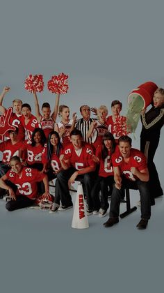 a group of young men and women posing for a photo with cheerleaders in red